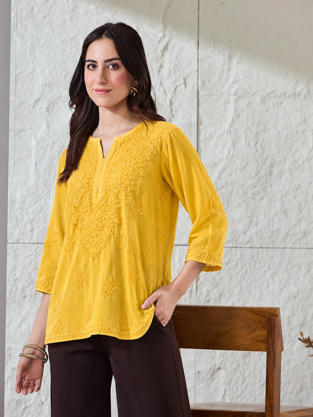Trending short Chikankari top for women with intricate embroidered floral patterns, soft rayon fabric, three-quarter sleeves and an easy-to-style regular wear silhouette.