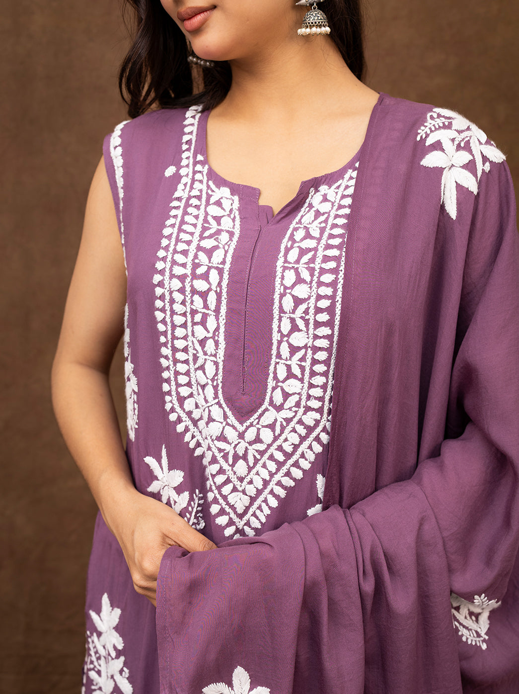 Sleeveless hand chikankari kurta featuring intricate embroidery across the front and hem, styled with embroidered pants and dupatta