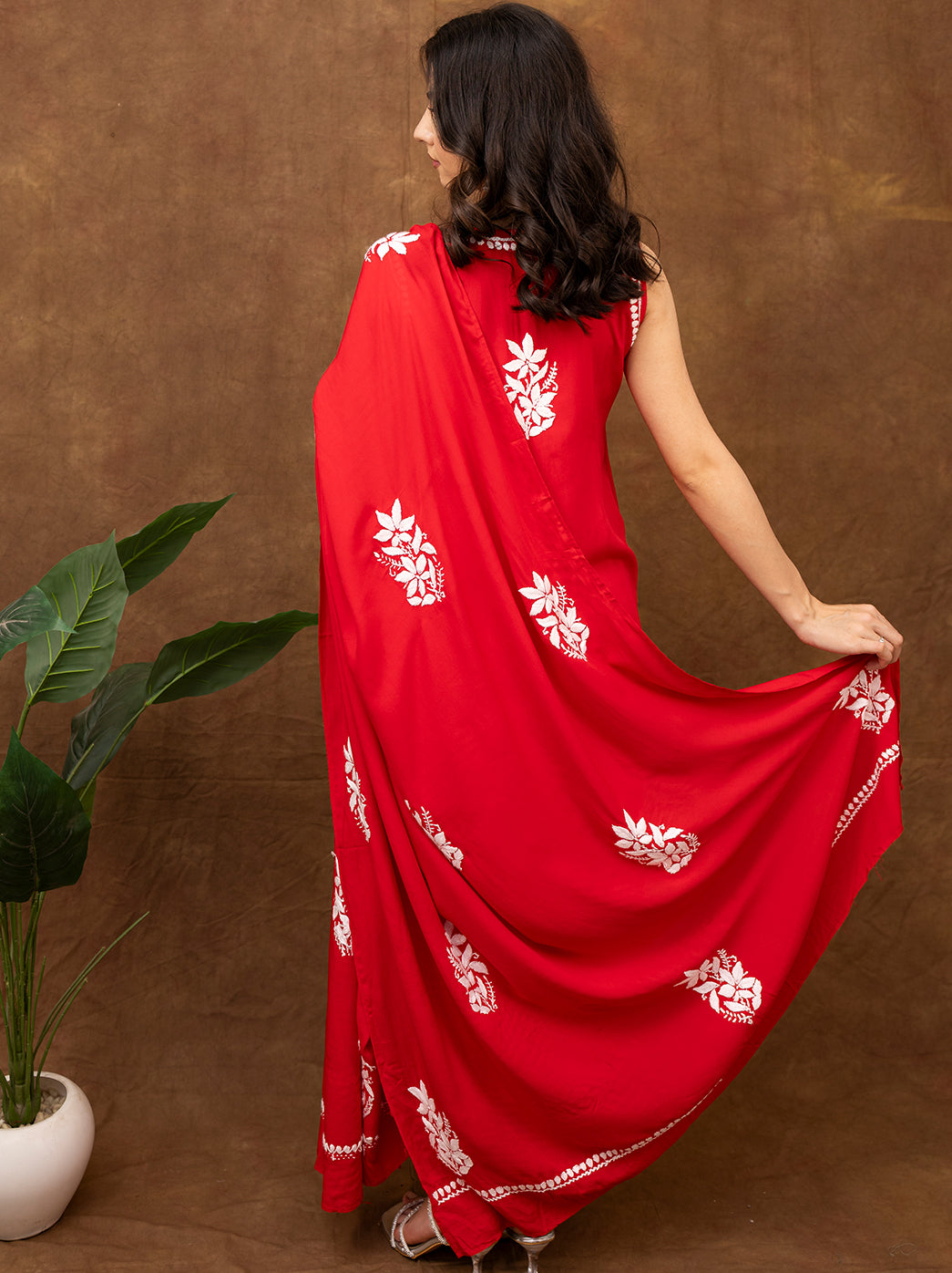 Elegant sleeveless chikankari kurta with all-over hand embroidery, worn with coordinated bottoms and dupatta, perfect for festive and traditional occasions