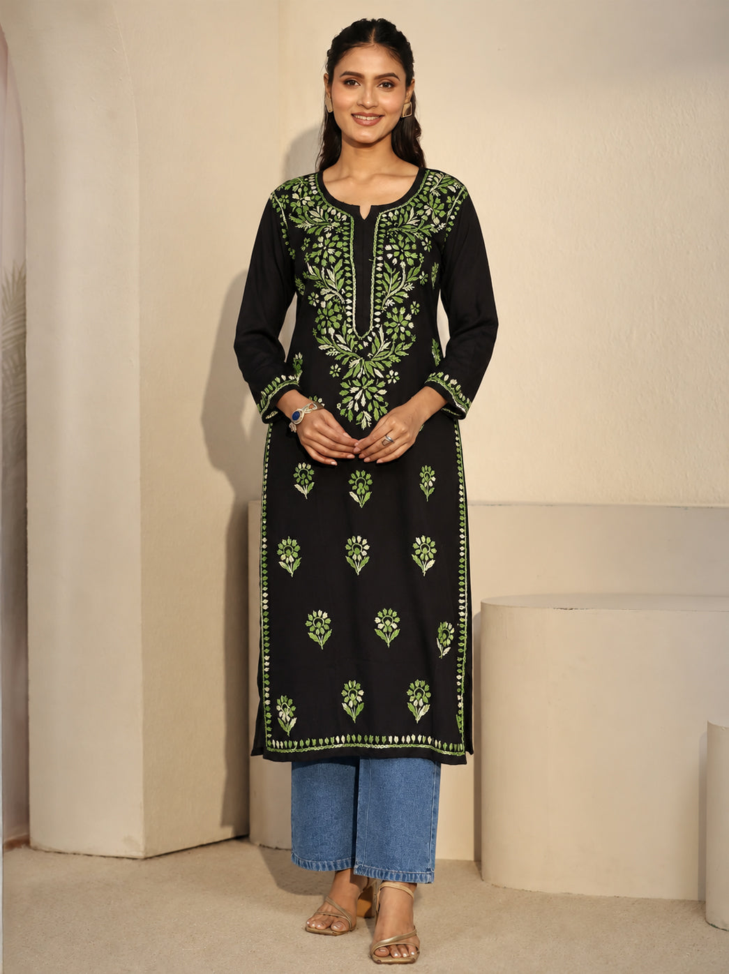 Full-length view of the Ayra Rayon Straight Kurti with floral and leafy embroidery around the neckline, scattered front motifs and embroidered hem borders, paired with cropped jeans.