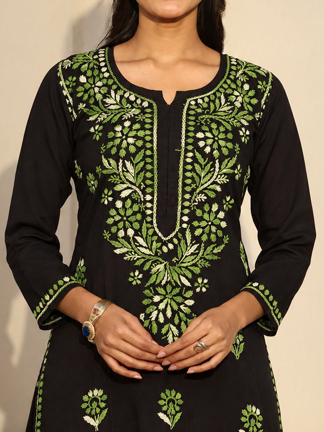 Ayra Rayon Straight Kurti shown on a model standing with her hands together, highlighting the long straight silhouette, side slits and detailed Chikankari embroidery across the front.