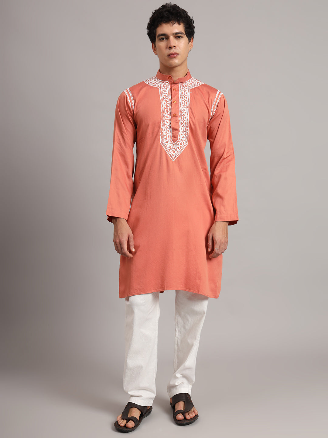 Front-facing model in the Uman men's Chikankari kurta, showing the placement of embroidery around the collar, down the chest and along both shoulder seams.