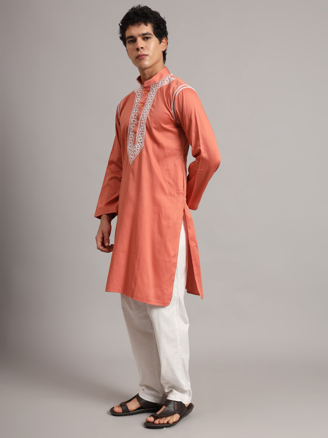 Full outfit photograph of a model wearing the Uman Mens Kurta, highlighting its straight silhouette, embroidered shoulder accents and detailed traditional neckline.