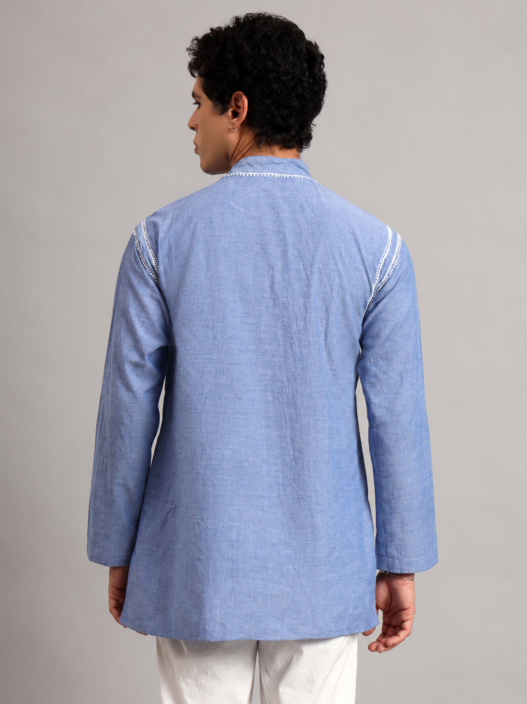Male model wearing the Denim Mens Kurta with leafy neckline embroidery and narrow decorative borders along both shoulders, photographed against a plain studio background.