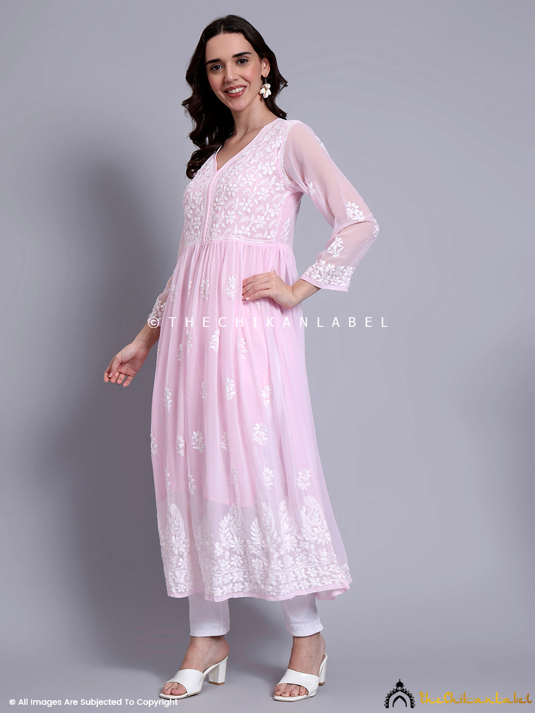 Model posing in a flowy chikankari kurti with V-neckline and full sleeves, showcasing Indian hand embroidery.

