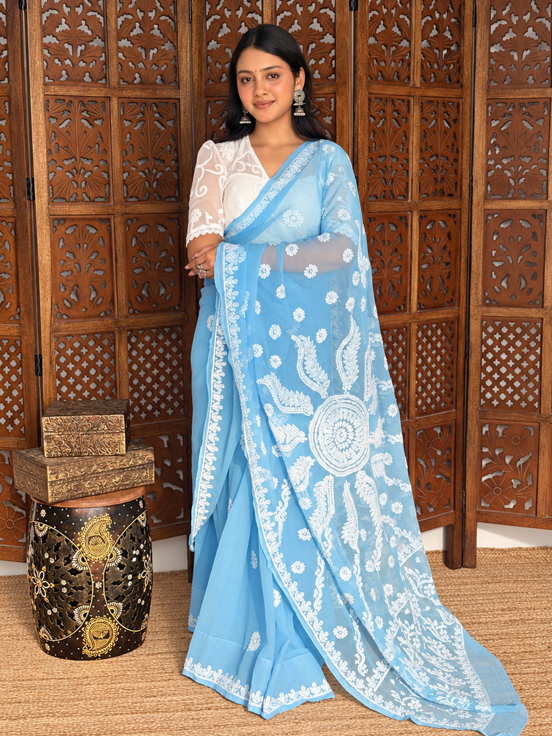 Dityaa Georgette Chikankari Saree featuring intricate white floral embroidery, an elegant decorative pallu, delicate traditional motifs, and a beautifully embroidered border styled on a model for a premium Indian ethnic fashion look.