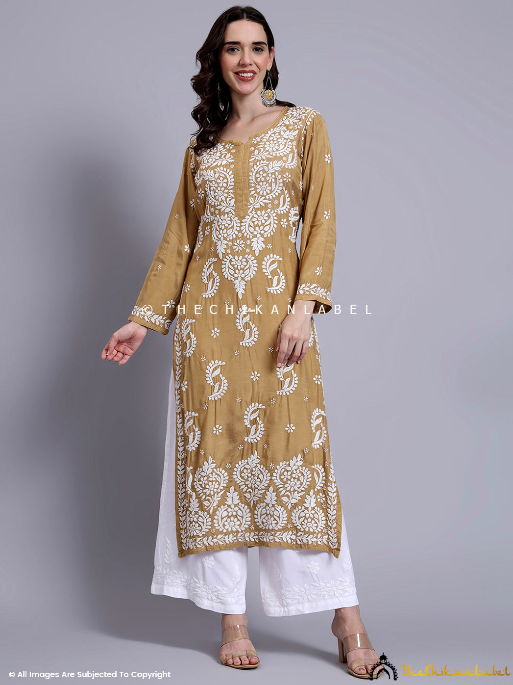 Muslin kurti for women displayed on a hanger with visible hand embroidery and straight cut silhouette.

