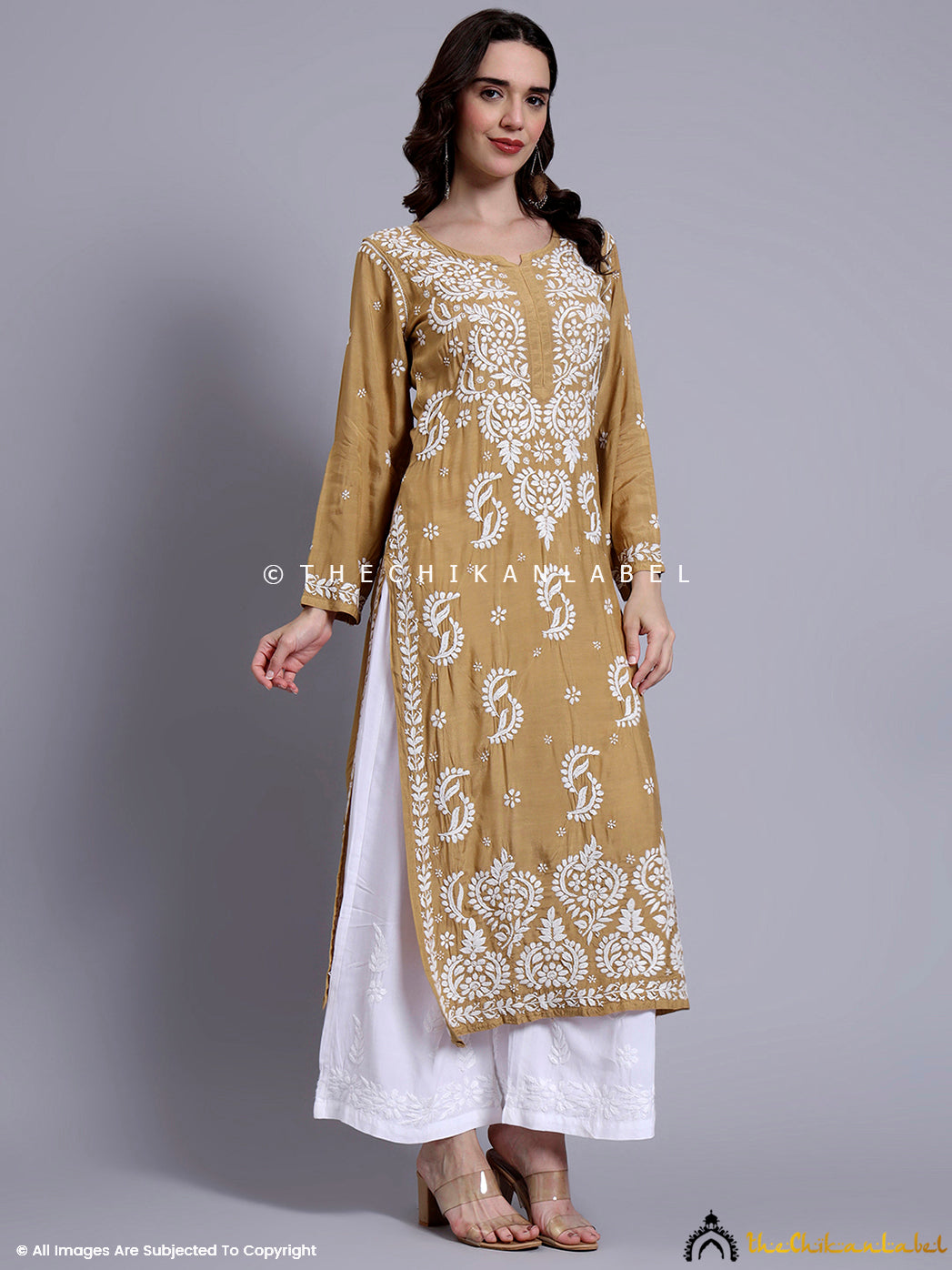 Hand-embroidered muslin kurti showcased on a mannequin with straight-fit tailoring and neckline detail.

