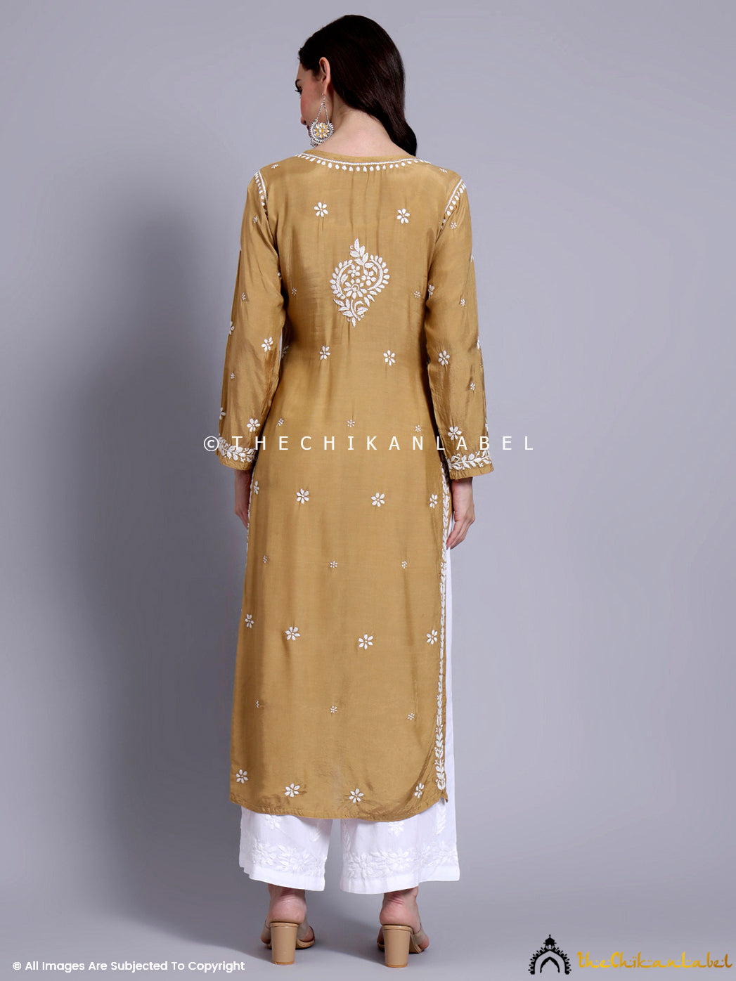 Flat-lay of a muslin chikankari straight kurti arranged with ethnic earrings and a dupatta.

