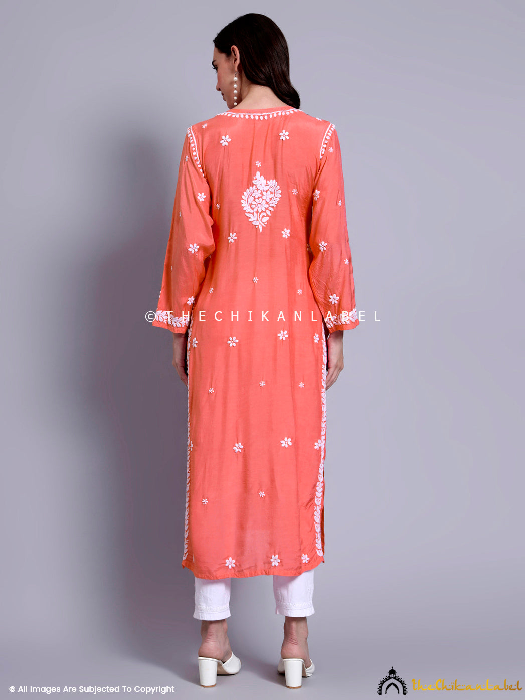 Boutique-style display of a muslin chikankari kurti folded neatly with close-up on the embroidery.

