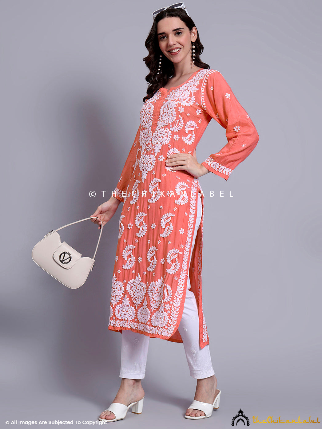 Premium muslin straight kurti with chikankari embroidery styled in a natural daylight setting for catalog use.

