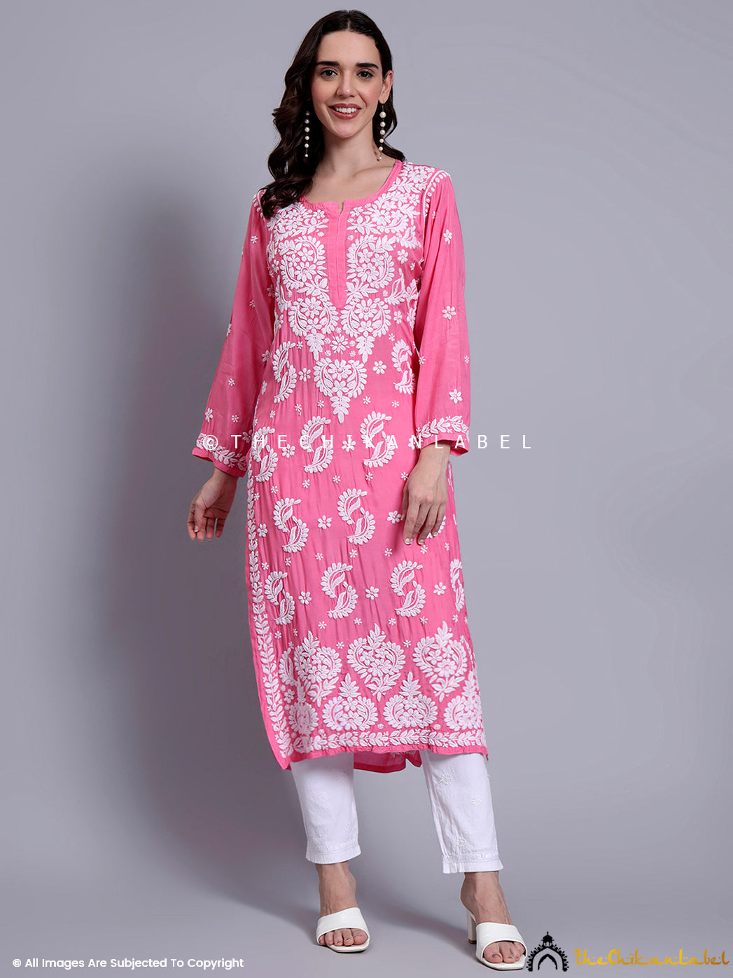 A model wearing a handcrafted muslin chikankari straight kurti styled with white embroidered bottoms and heels.

