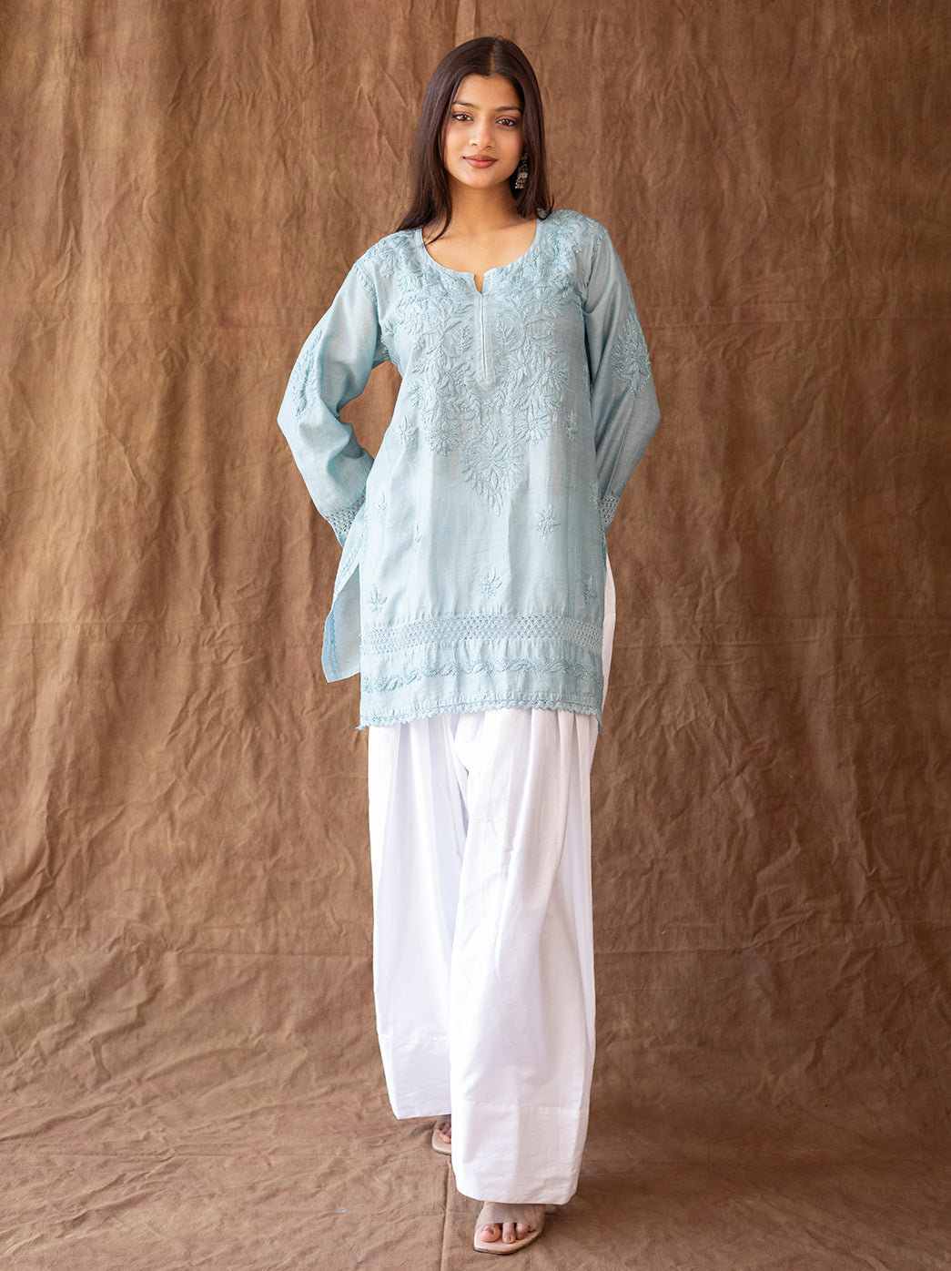 Traditional chikankari kurti showcasing delicate embroidery patterns, worn with flowing farshi salwar for festive and cultural occasions