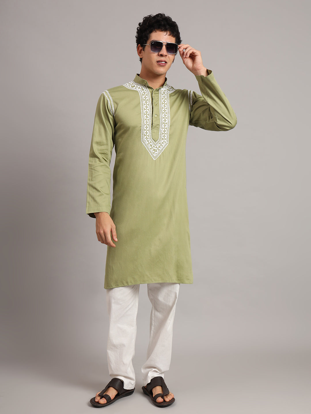 Men's ethnic outfit featuring the Uman Chikankari kurta, with a structured mandarin neckline, long sleeves and a straight silhouette paired with trousers and open-toe sandals.