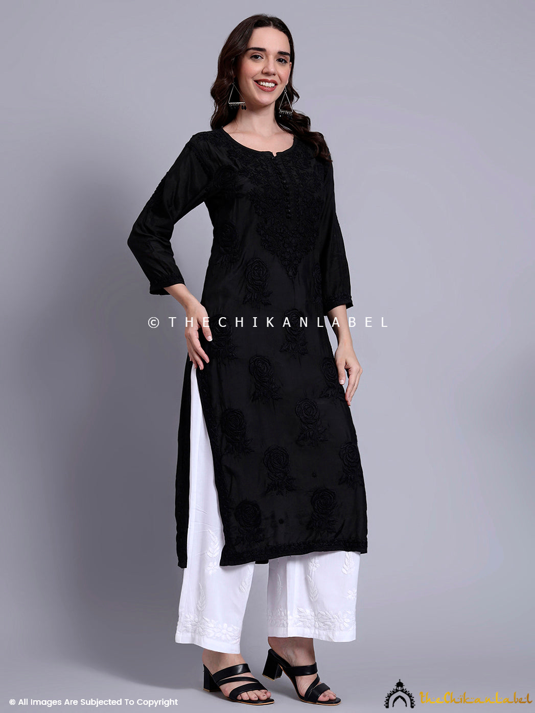 Hand-embroidered muslin kurti designed with a round neckline and side slits, styled with wide-leg ethnic pants for a graceful everyday look.


