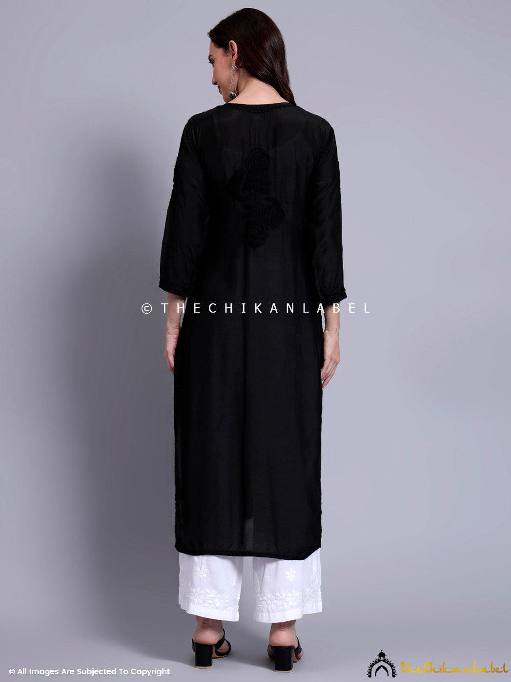 Elegant ethnic outfit showcasing a straight-fit muslin kurti with handcrafted embroidery and front fabric buttons for festive or workwear styling.

