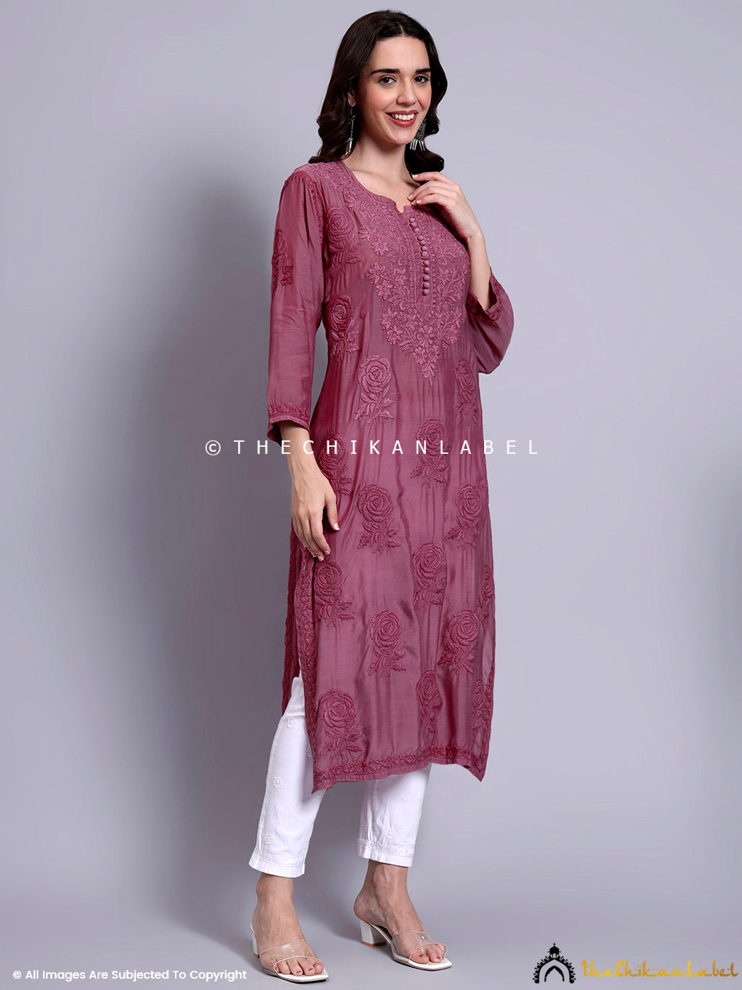 Elegant ethnic outfit showcasing a straight-fit muslin kurti with handcrafted embroidery and front fabric buttons for festive or workwear styling.

