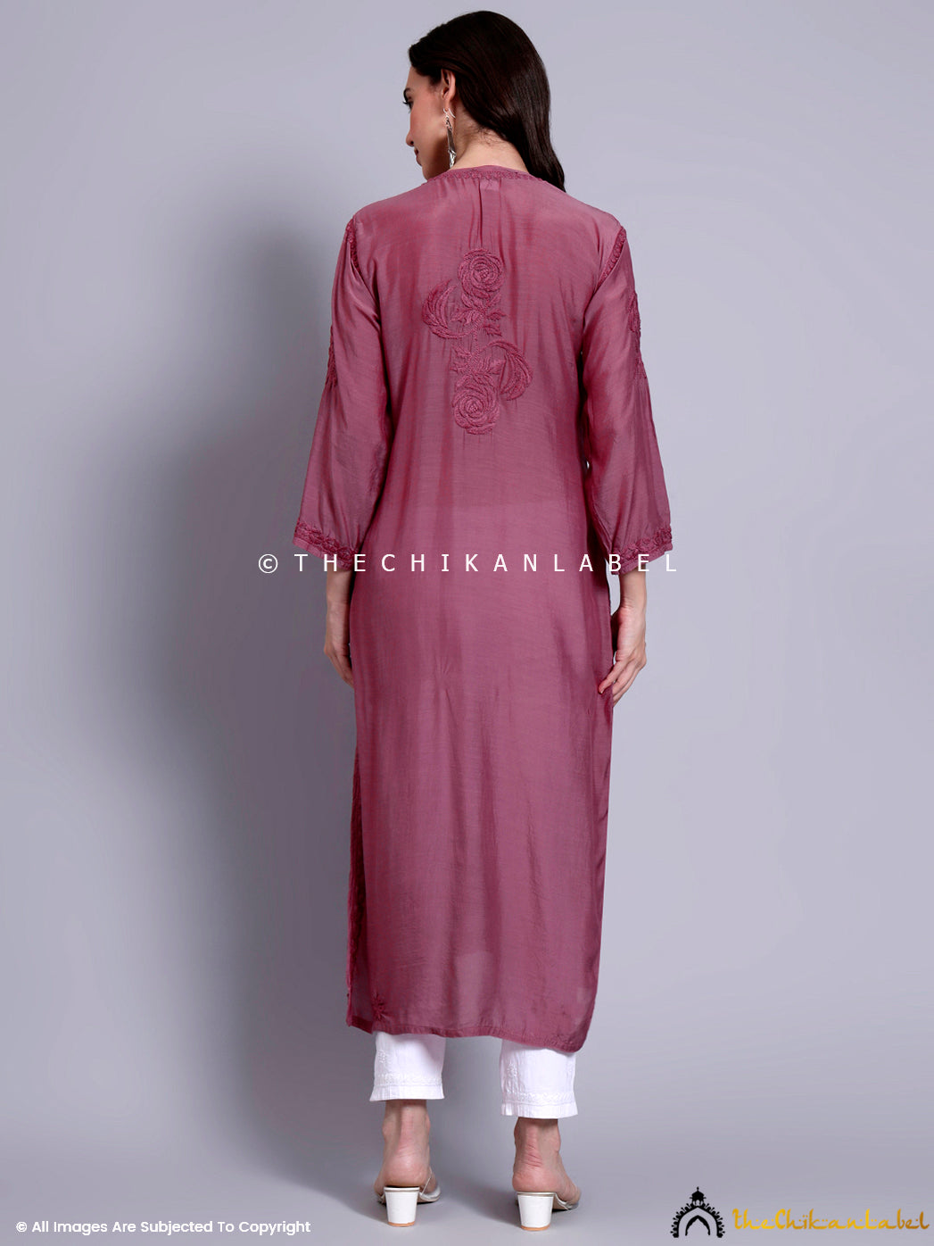 Woman wearing handcrafted muslin chikankari straight kurti featuring intricate tone-on-tone embroidery and a straight silhouette, paired with contrast palazzo pants.


