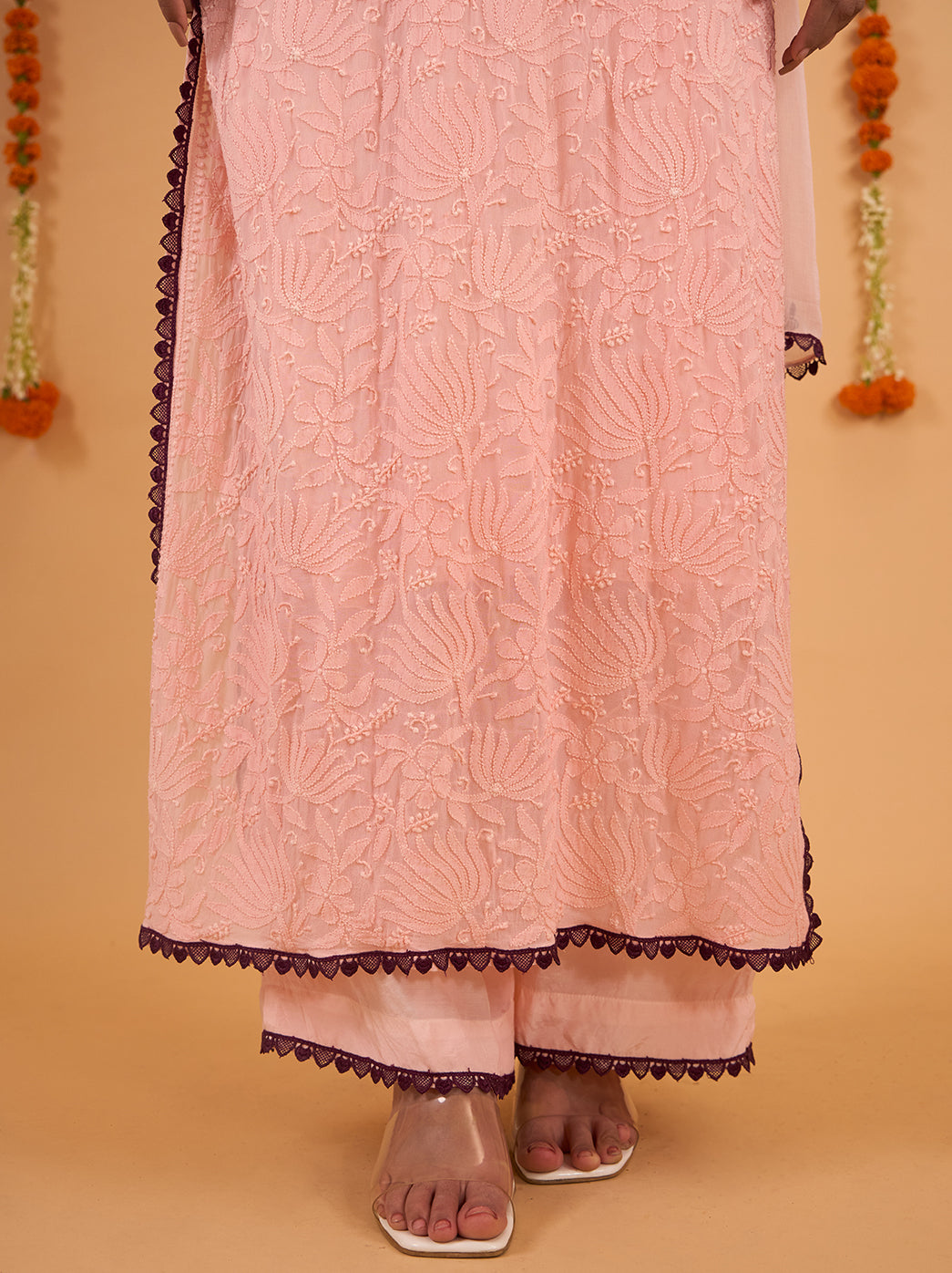 Model wearing the Gulnaar straight kurti with one hand resting near her hair, revealing the sleeve embroidery and lace edging around the cuff.
