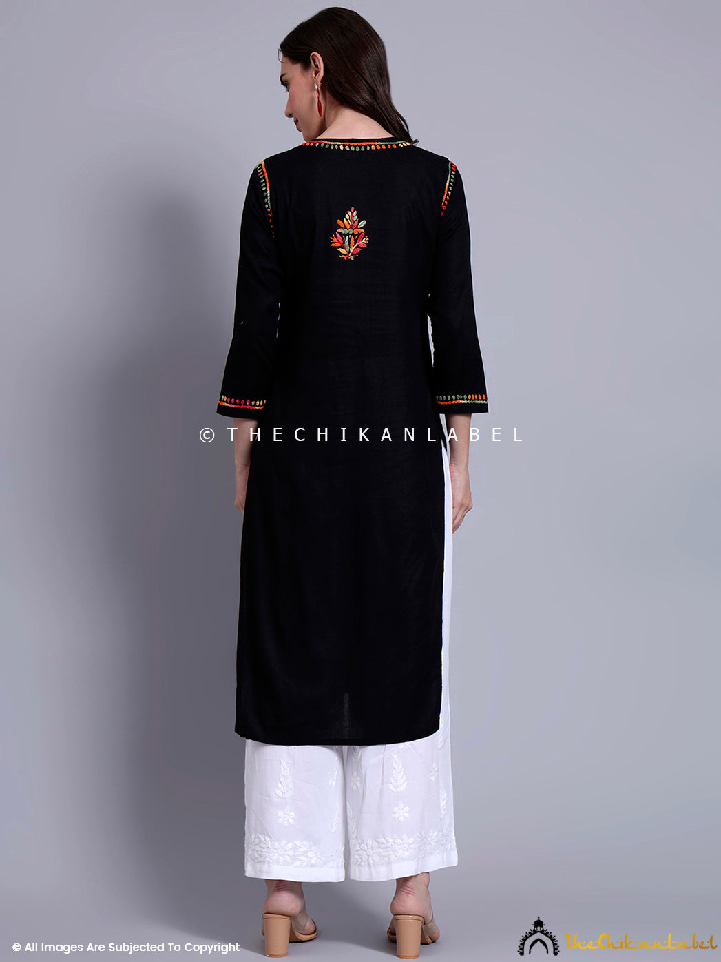 Full-length image of ethnic kurti with straight silhouette and colorful embroidery, paired with wide-leg pants and minimal accessories.

