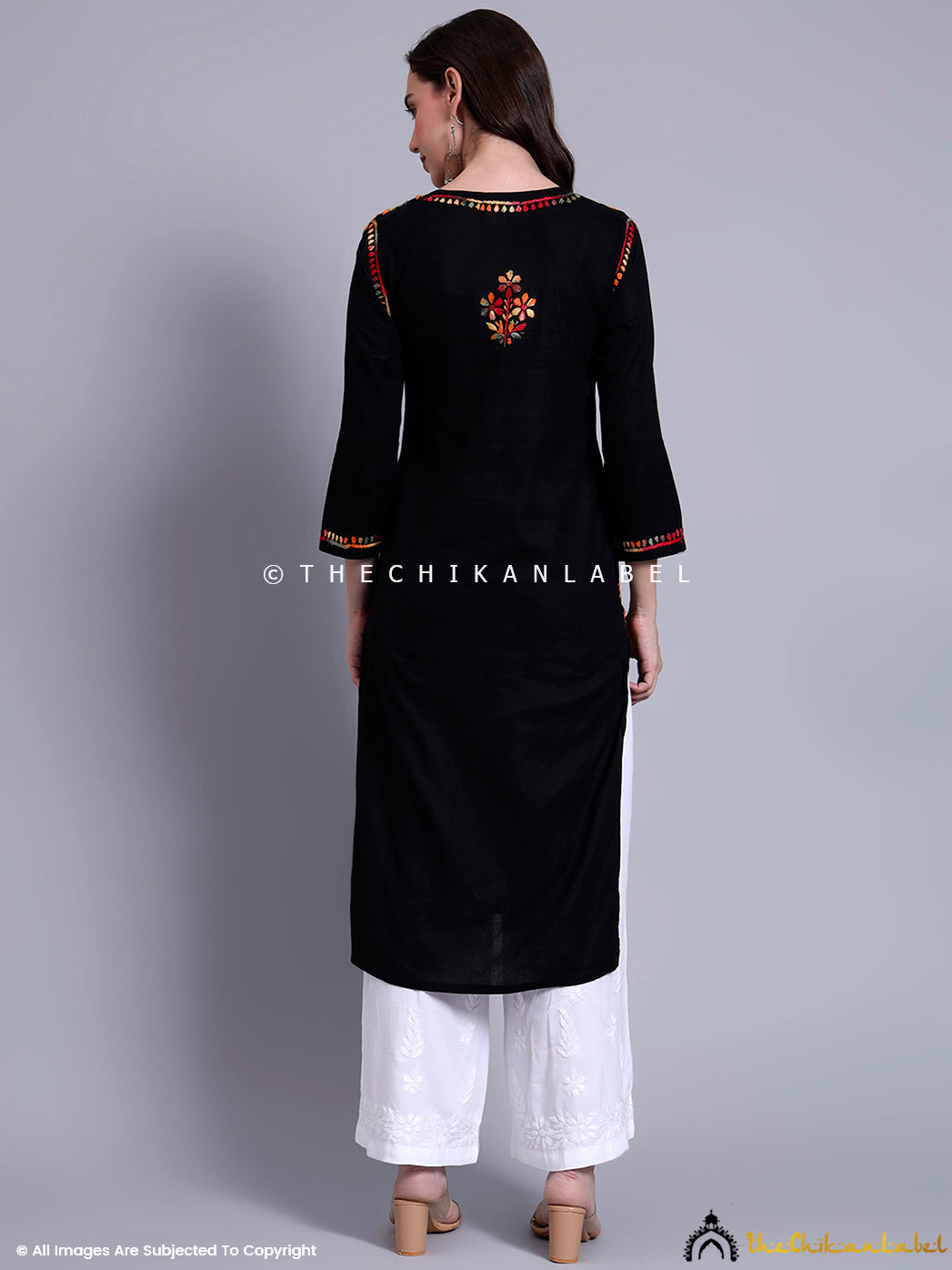 Full-length image of ethnic kurti with straight silhouette and colorful embroidery, paired with wide-leg pants and minimal accessories.

