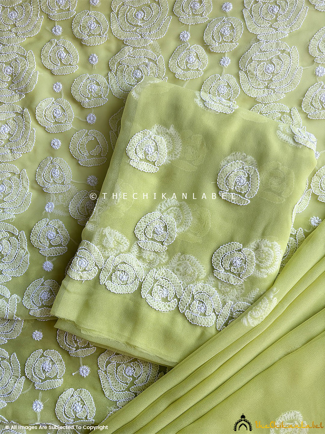 “Close-up of detailed hand-embroidered chikankari work on unstitched georgette suit material with dupatta”