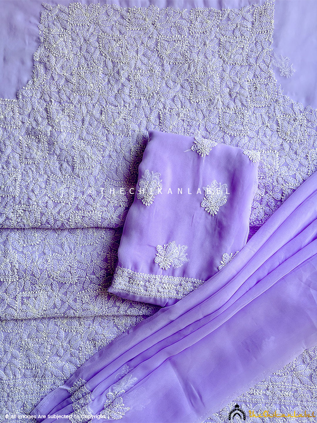 “Close-up of detailed hand-embroidered chikankari work on unstitched georgette suit material with dupatta”