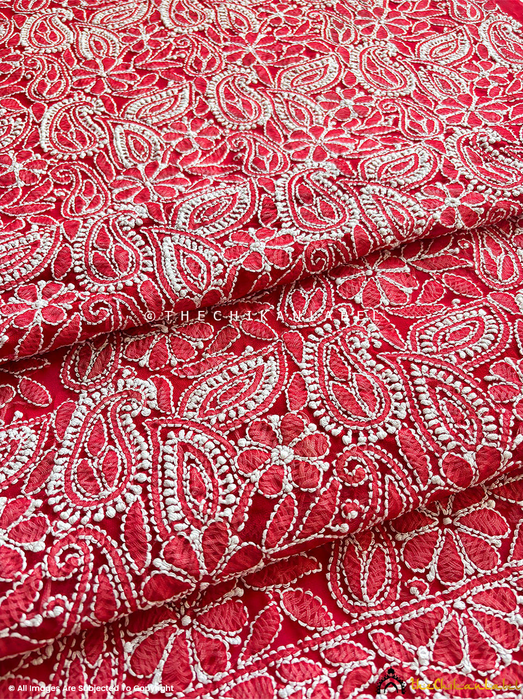 “Close-up of detailed hand-embroidered chikankari work on unstitched georgette suit material with dupatta”