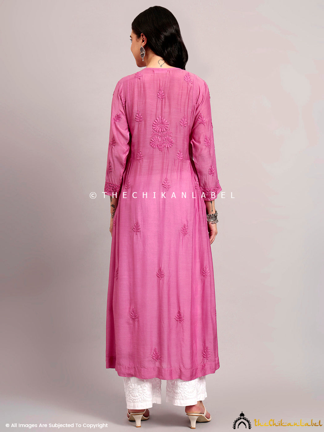 A-line kurti with intricate floral chikankari detailing styled with traditional jhumkas.

