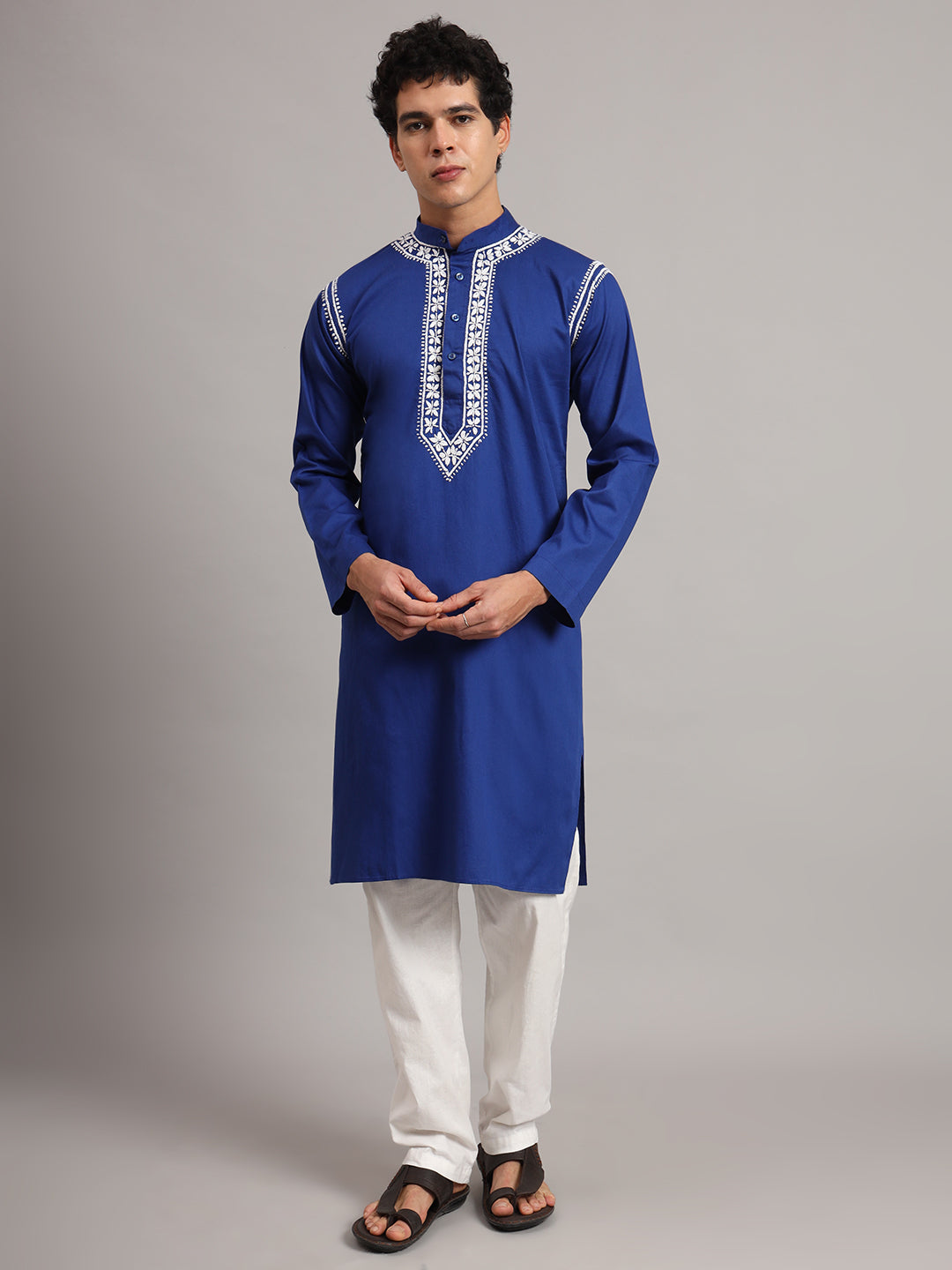 Front-facing model in the Uman men's Chikankari kurta, showing the placement of embroidery around the collar, down the chest and along both shoulder seams.