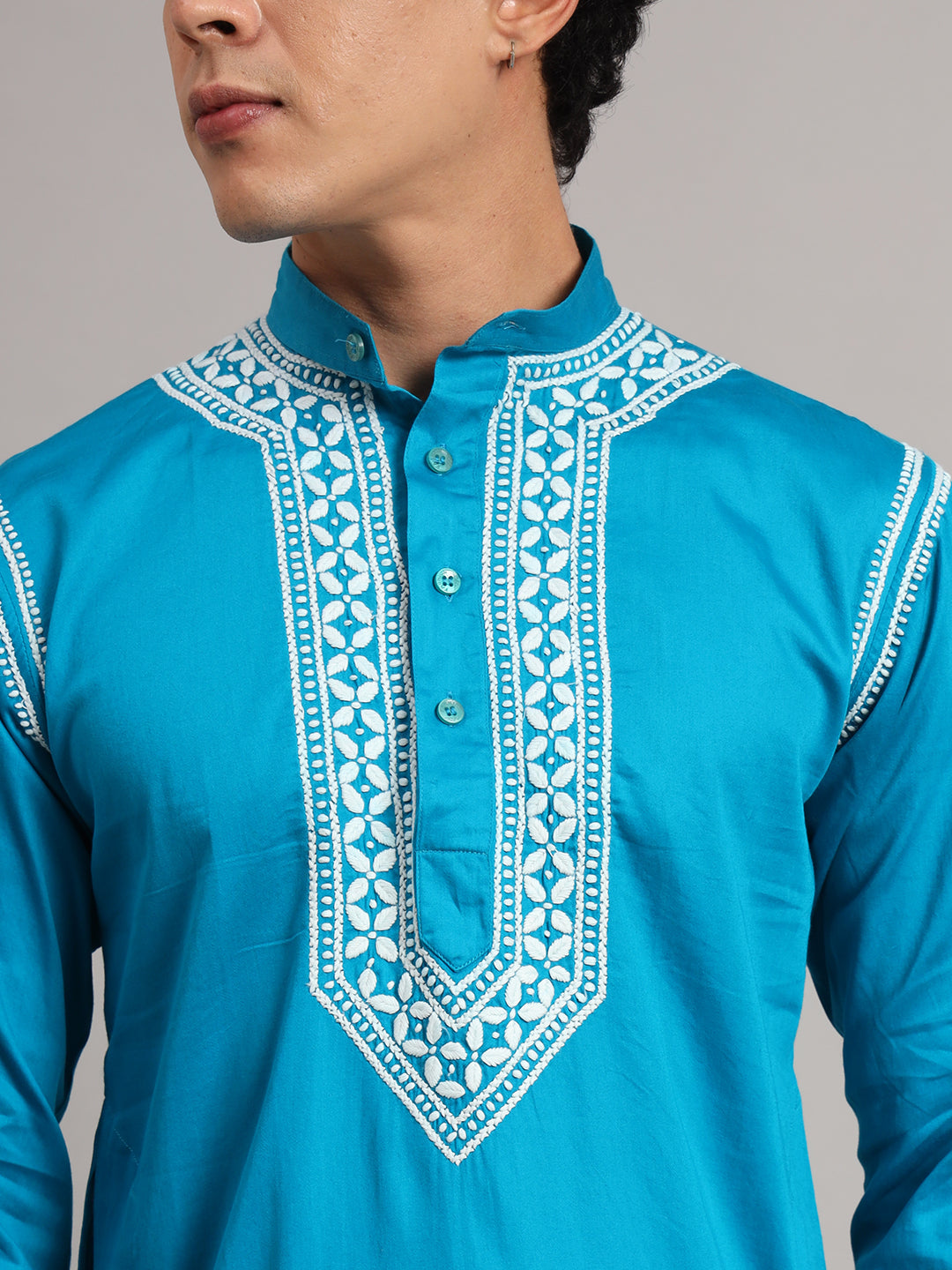 Men's Uman Chikankari kurta featuring a mandarin collar, full sleeves and narrow embroidered shoulder accents, styled with straight trousers and open-toe sandals.