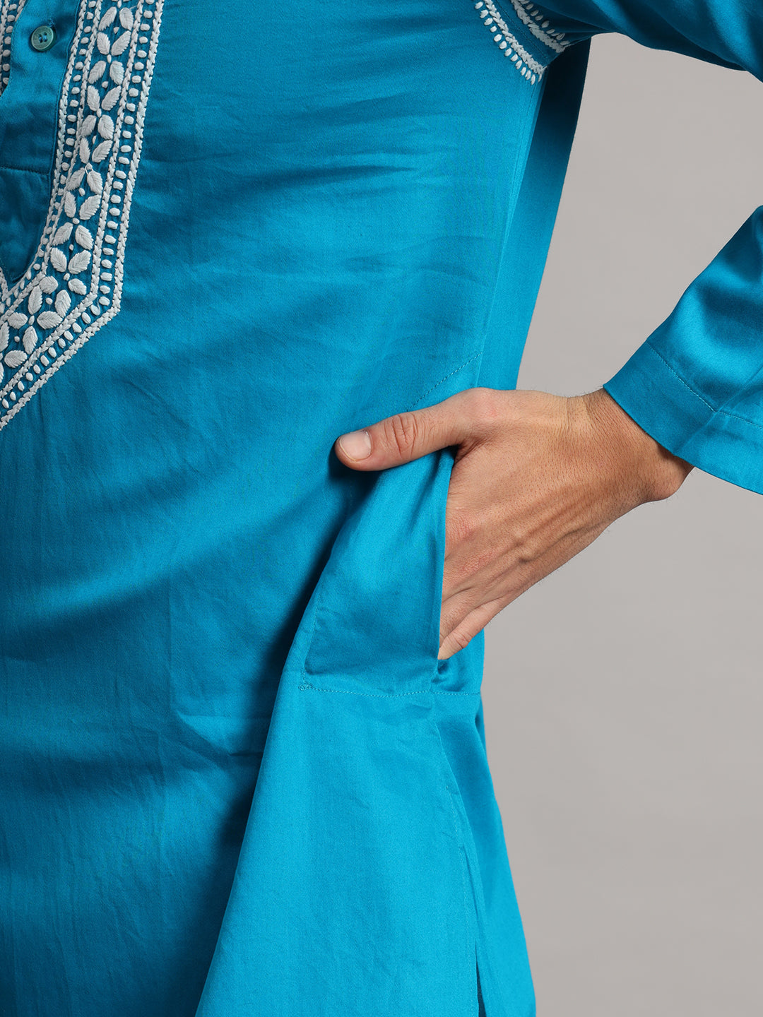 Uman men's ethnic kurta featuring a standing collar and an elongated embroidered placket, worn with straight trousers that remain visible below the knee-length hem.