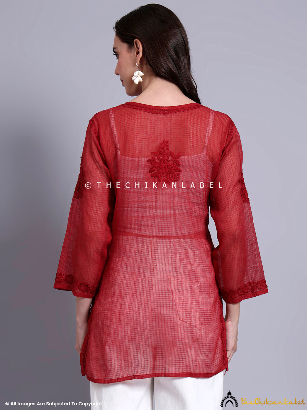 Model dressed in a kota cotton short top with hand-embroidered Chikankari work and straight long sleeves.

