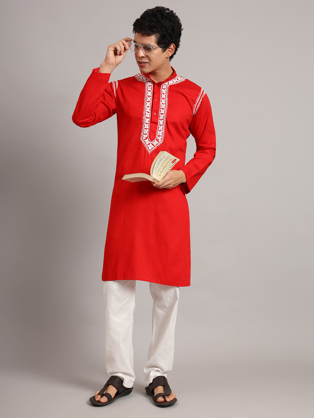Uman men's ethnic kurta featuring a standing collar and an elongated embroidered placket, worn with straight trousers that remain visible below the knee-length hem.