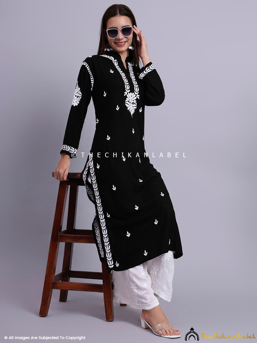 Traditional straight kurti with detailed chikankari motifs, styled with statement earrings and heels.

