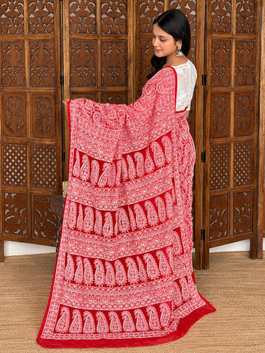 Sahira georgette saree featuring a sheer embroidered shoulder drape, open sections between floral motifs and a decorative border around the lower hem.