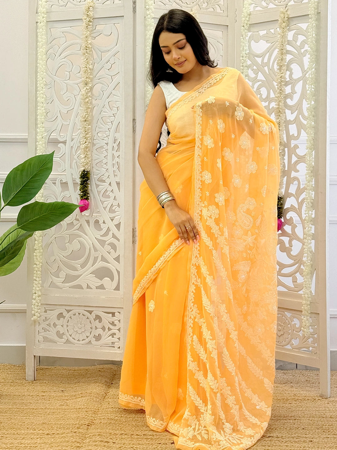 Luxurious georgette chikankari saree designed for festive occasions with detailed floral and paisley embroidery motifs.