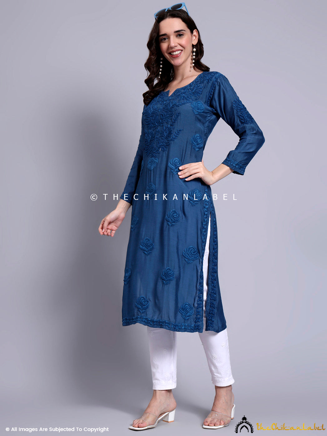 Traditional straight-fit kurti with authentic Lucknowi chikankari detailing on breathable muslin fabric, styled with plain bottom and light accessories.

