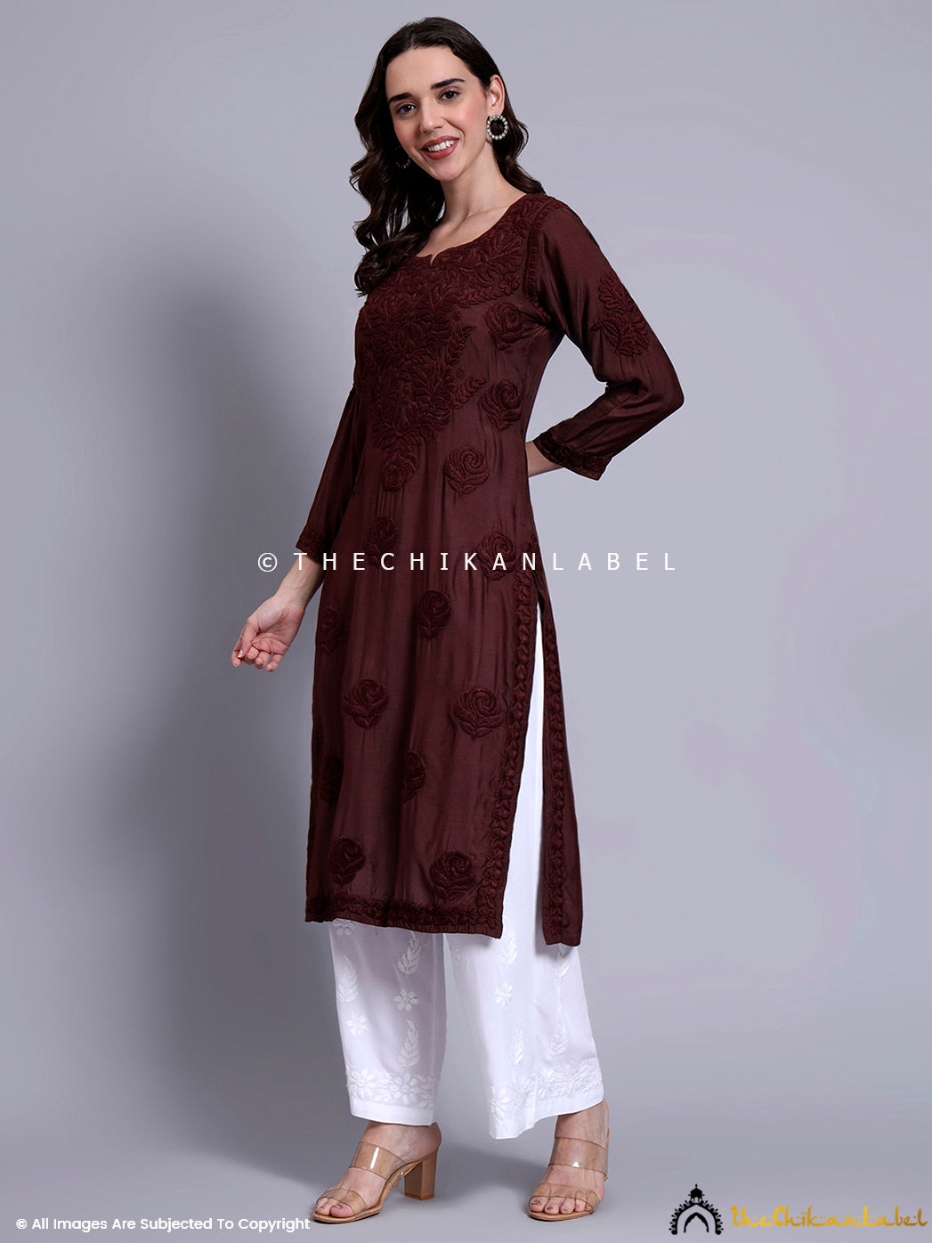 Model wearing lightweight muslin kurti featuring traditional chikankari work and straight silhouette, styled with white straight-fit trousers.

