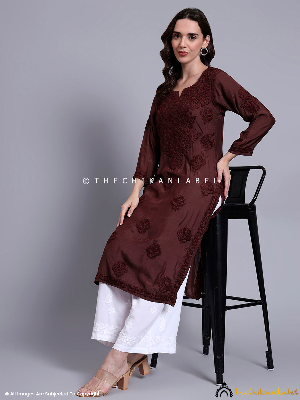 Muslin kurti with intricate front embroidery and soft fabric texture, worn with contrast bottoms and subtle statement earrings.

