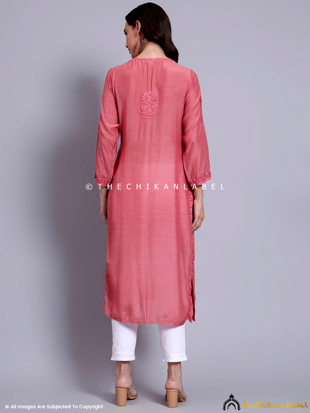 Woman wearing handcrafted muslin chikankari straight kurti with intricate floral embroidery, paired with contrast palazzo pants, ideal for office and casual occasions.

