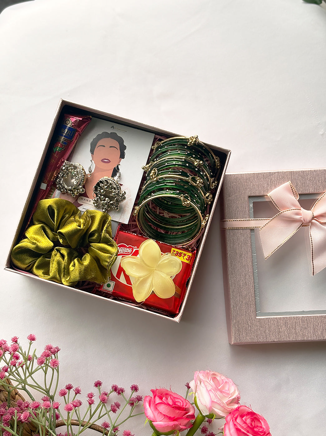 Traditional Sawan gift box containing oxidised earrings, a coordinated bangles set, mehndi, bindi, hair accessories and packaged chocolate.