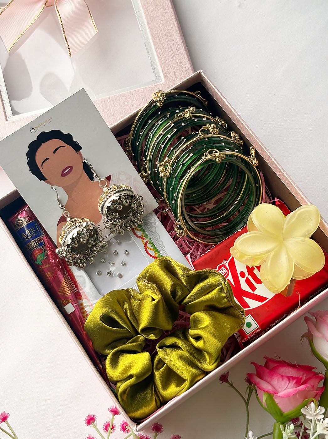 Hariyali Teej and Sawan gift hamper featuring traditional bangles, ethnic earrings, mehndi, bindi, hair accessories and a chocolate treat.