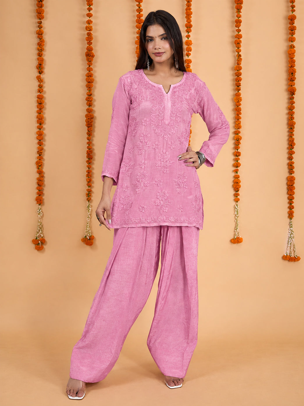 Model wearing a Shagun muslin kurti and Farshi pant set, showing the rounded slit neckline, embroidered sleeve borders and softly draped fabric.