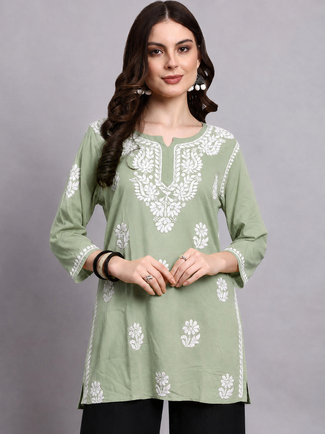 Comfortable regular wear top for women featuring traditional Chikankari embroidery, notched round neckline and an easy-to-style short kurta design.
