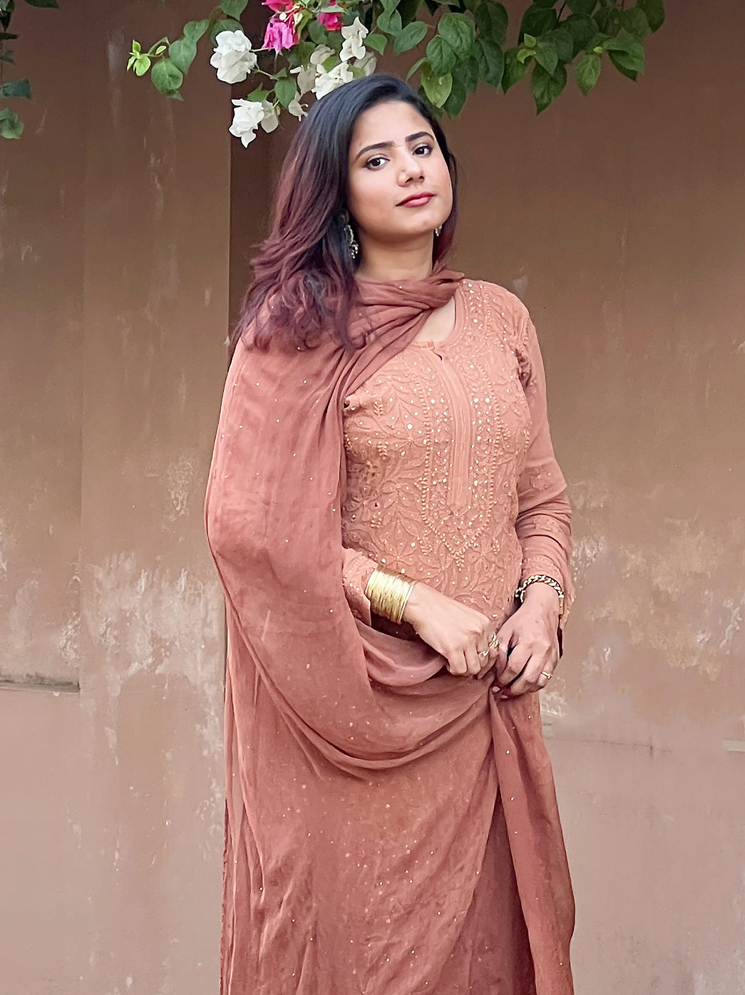 Woman wearing elegant chikankari kurta set with mukaish work showcasing detailed front embroidery design