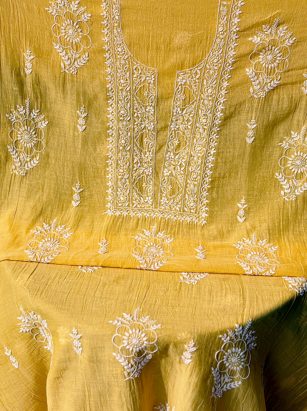 Close-up view of Mul Chanderi unstitched kurti fabric with intricate hand-embroidered Chikankari neckline and floral vine motifs.