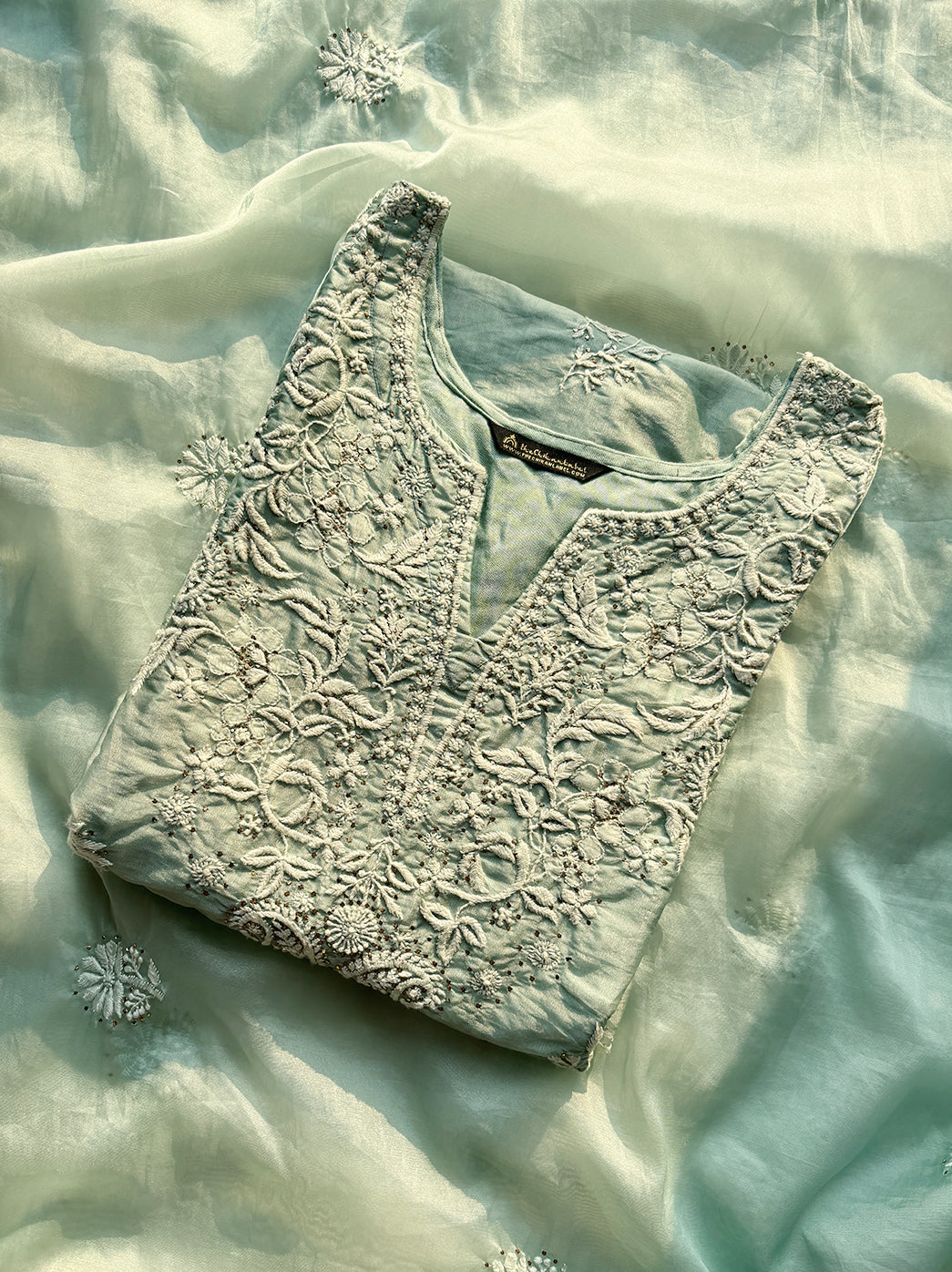 “Model wearing stitched chikankari kurti set in organza with matching embroidered dupatta and pant”