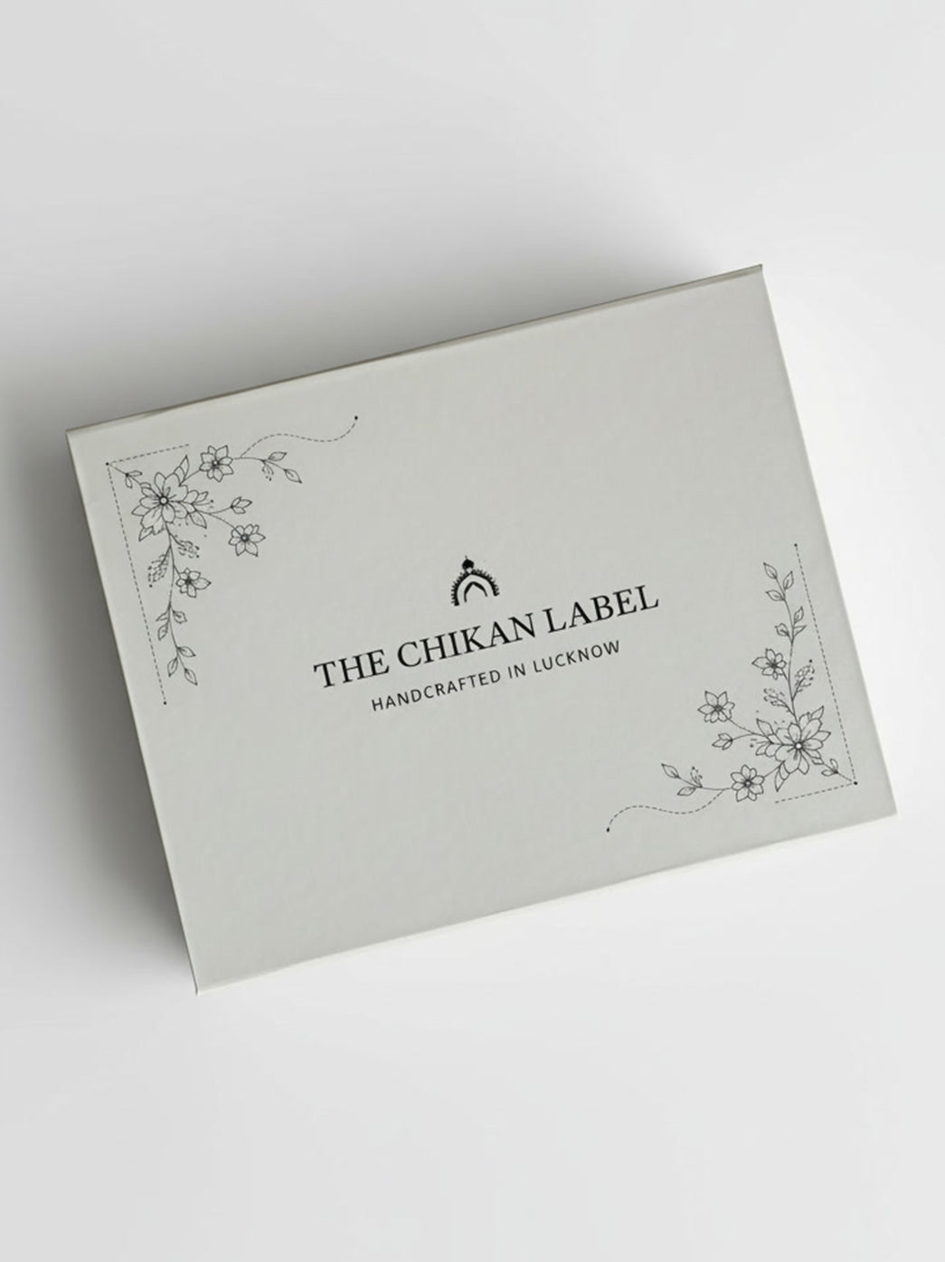 Chikanlabel Gift Box shown from an elevated angle, featuring a rectangular lid with delicate floral corner illustrations and The Chikan Label logo at the centre.