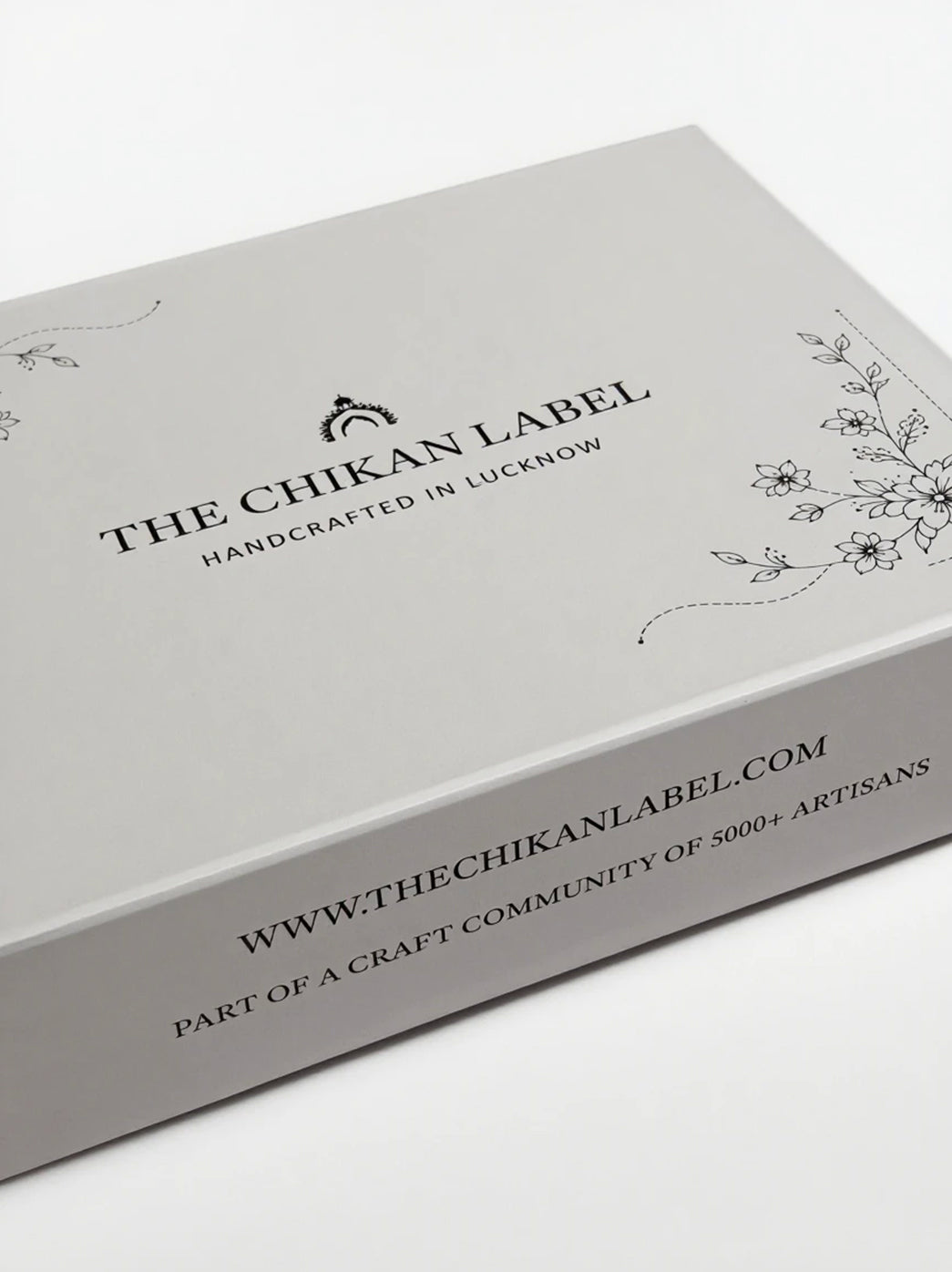 Premium gift box by The Chikan Label featuring floral line drawings on the lid, a fitted rectangular structure and printed branding across the front panel.
